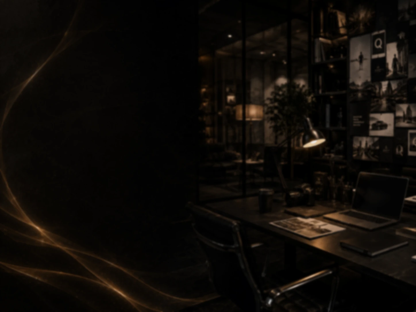 Dark brand studio workspace with mood boards, printed layouts and a laptop under warm lighting